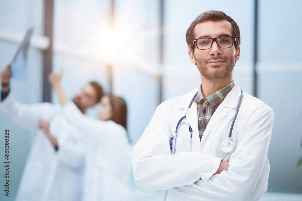 Confident doctor posing with arms crossed, he is smiling at camera Confident doctor posing with arms crossed, he is smiling at camera