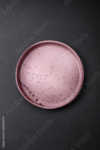 Empty round ceramic plate on a dark textured background
