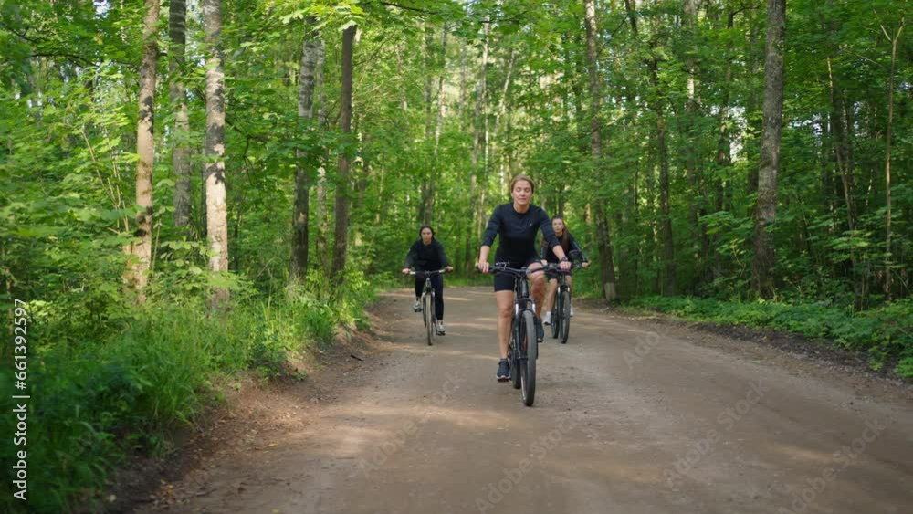 Three Slender Women Riding Bicycles In Beautiful Woodland In Summer Morning, Active Rest In Nature Three Slender Women Riding Bicycles In Beautiful Woodland In Summer Morning, Active Rest In Nature