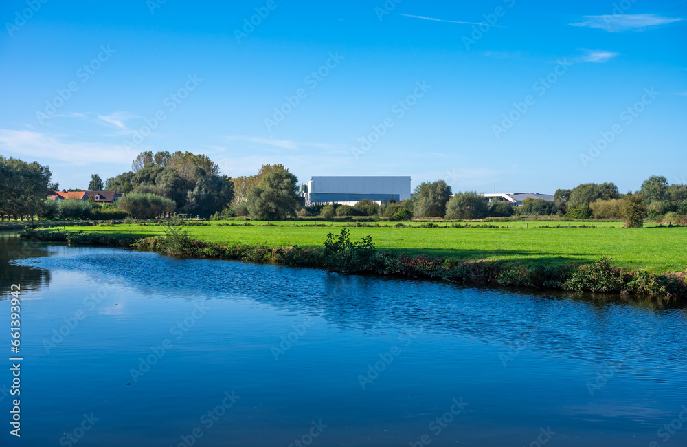 Industrial buidling reflecting in the water of the river Dender, Ninove, Flemish Region, Belgium