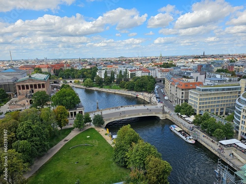 A meandering river flows through the bustling city, while a majestic bridge stands tall beside it, connecting both sides.