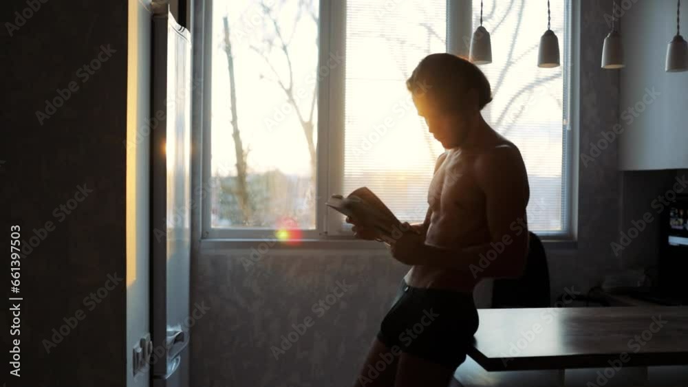 naked-chested man reading a book at home, education concept at home. naked-chested man reading a book at home, education concept at home.