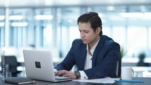 Stressed Indian corporate employee working on laptop
