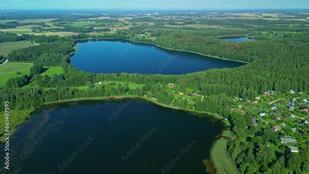 Drone shot slowly descending over a small neighborhood near a forest and lakes Drone shot slowly descending over a small neighborhood near a forest and lakes