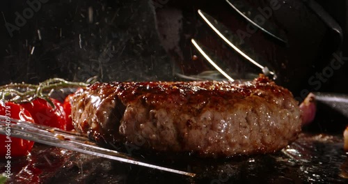 Chef takes frying vegetarian cutlet and turns around using kitchen spatulas on pan preparing Burger. Cinematic advertising plant-based imitation burger cooking. High-protein food option, delicious