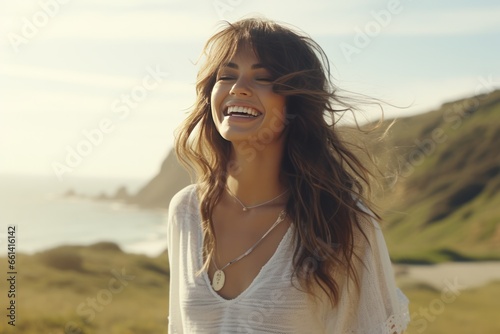 Portrait of beautiful young woman with long brown hair smiling and looking away on the beach.