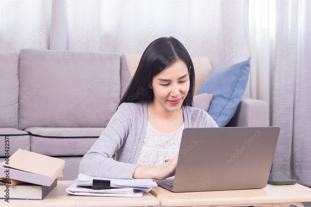 Asian happy female working at home calculate bookkeeping for tax declarations using modern technology laptop, well-organized planning financial payment for housing loan, women working paperwork bills Asian happy female working at home calculate bookkeeping for tax declarations using modern technology laptop, well-organized planning financial payment for housing loan, women working paperwork bills