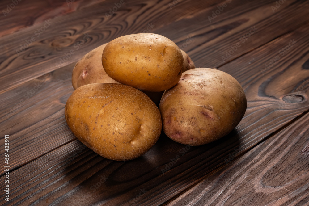 Fresh harvested potatoes on a rough wooden surface Fresh harvested potatoes on a rough wooden surface