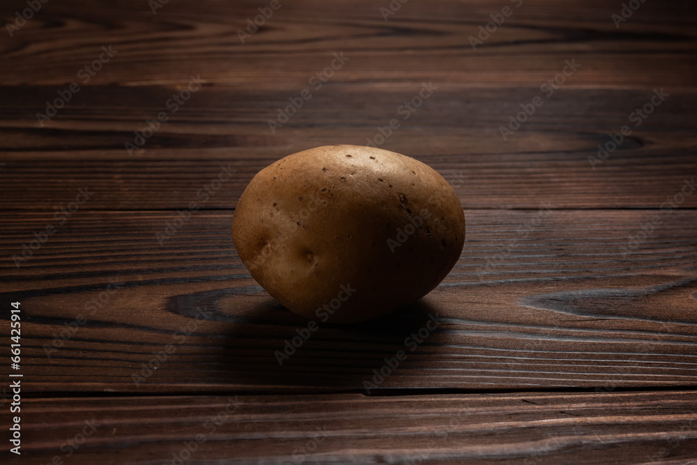 Fresh harvested potato on a rough wooden surface Fresh harvested potato on a rough wooden surface