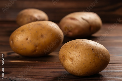 Fresh harvested potatoes on a rough wooden surface