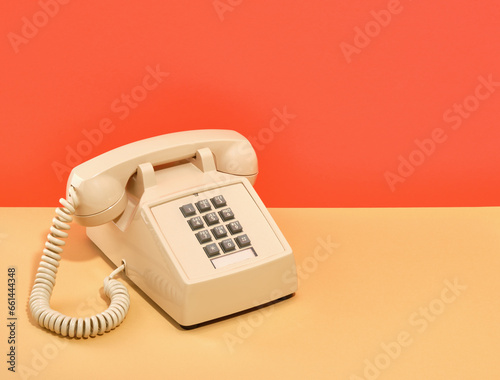 A composition of old vintage beige phone with gray buttons on table. Copy space for text.
