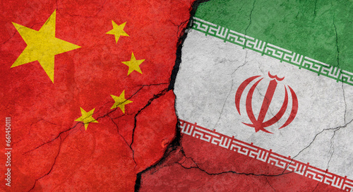 Flags of China and Iran, concrete wall texture with cracks, grunge background, military conflict concept