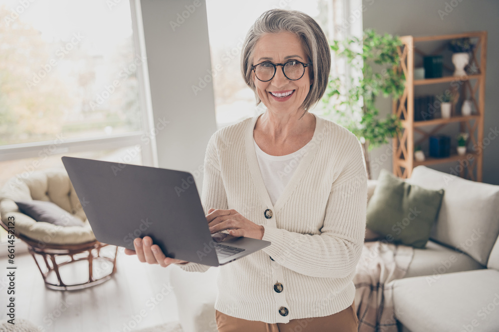 Photo of adorable pretty senior lady dressed white cardigan working modern device indoors house room Photo of adorable pretty senior lady dressed white cardigan working modern device indoors house room
