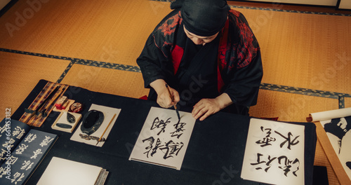 Photography Top Down View of a Japanese Male Calligraphy Artist Drawing Aesthetic Spiritual Symbols in Kanji Characters