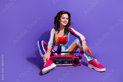 Photo of pretty lady in pin up clothes sitting floor on discotheque with boom box isolated bright color background