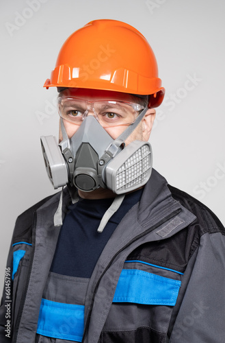 A man wearing a helmet, respirator and goggles on a white background © Zarina Lukash