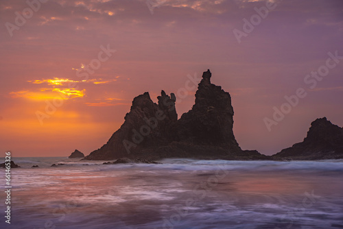 fiery summer sunset behind the typical rocks of benijio beach in the north east of tenerife island © Marino Bocelli