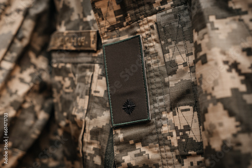 An element of the Ukrainian military uniform with chevrons and the shoulder strap of a junior lieutenant. Close-up, warm colors photo
