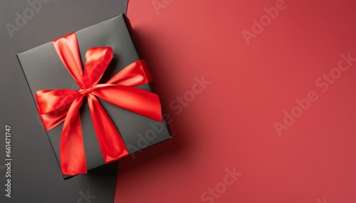Top view of black giftbox with red ribbon on two color red and black background with copy space © Loliruri