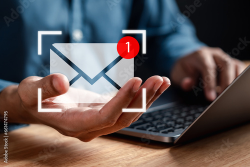 Businessman sending email by laptop computer to customer, business contact and communication, email icon, email marketing concept, send e-mail or newsletter, online working internet network. photo