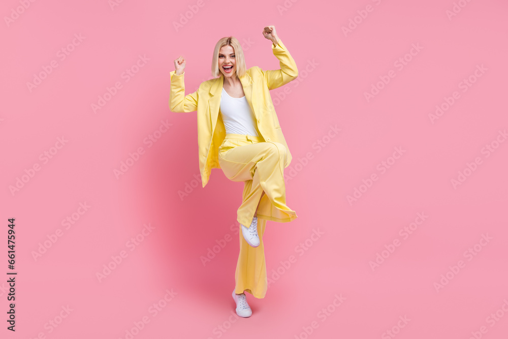 Full body photo of lovely delighted lady stand one leg raise fists accomplishment empty space isolated on pink color background Full body photo of lovely delighted lady stand one leg raise fists accomplishment empty space isolated on pink color background