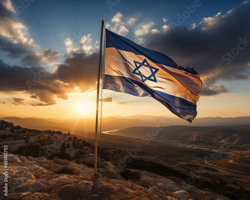 Israel flag on a flagpole on a hill against the background of dawn