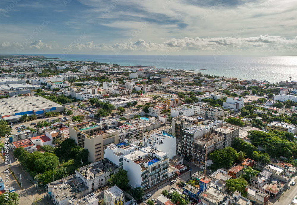 Drone view of Playa Del Carmen center area with light reflection on the Caribbean Sea in the background and cloudy sky