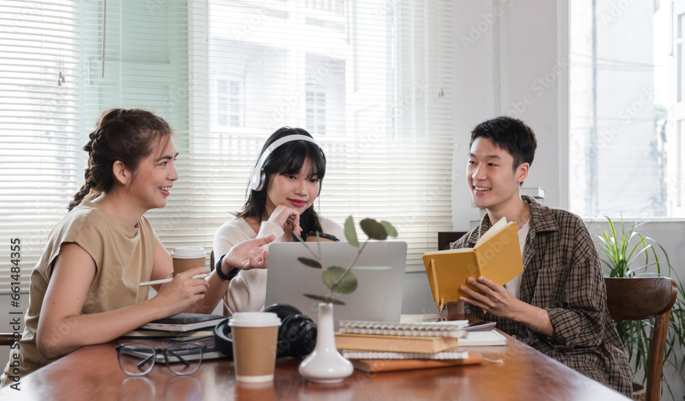 A group of cheerful Asian college students are enjoying talking and discussing their group project while sitting in a coffee shop together. A group of cheerful Asian college students are enjoying talking and discussing their group project while sitting in a coffee shop together.