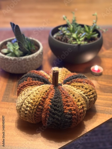 crochet pumpkin, succulents and a red tealight candle on a coffee table
