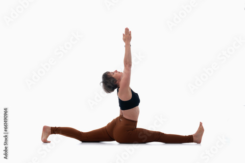 Asana pose - twine arms over head, Ashtanga yoga Side view of woman wearing sportswear doing Yoga exercise against white background.