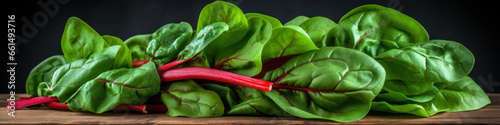 Fresh spinach leaves on wooden board over black background. Healthy food concept.
