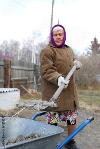 Old woman washes dishes, russian granny cleans the yard 