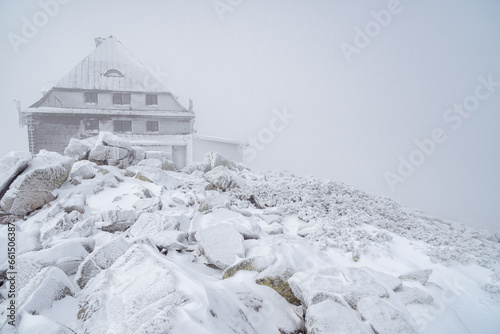 Fototapeta Naklejka Na Ścianę i Meble -  Amazing winter landscape with frozen rocks and stones around mountain hat on Szrenica peak in Karkonosze Mountains, Poland. Foggy winter scenery
