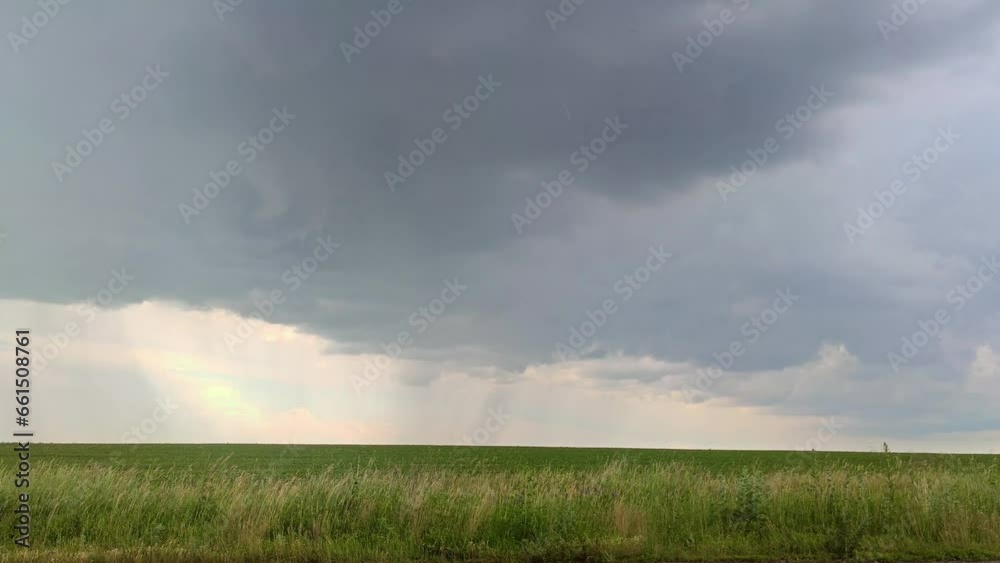 Pouring rain and wind on green field landscape with scenic heavy gray clouds, rural landscape Pouring rain and wind on green field landscape with scenic heavy gray clouds, rural landscape