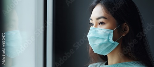 Isolated woman wearing a face mask indoors experiencing anxiety and mental health issues during the pandemic photo