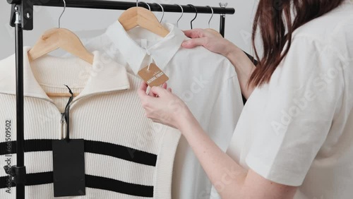 Beautiful lady stylist choosing her fashion outfit clothes.  Woman think what to wear. Stylist near rack with hangers. Home wardrobe, selection of a wardrobe, stylist, shopping.