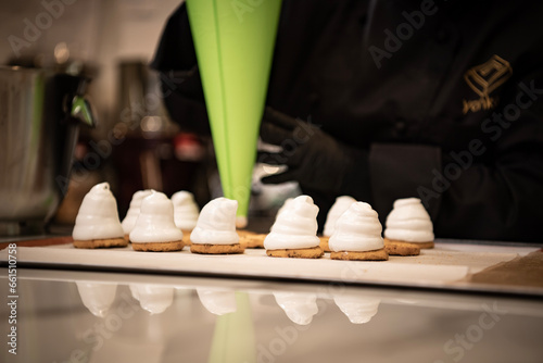 Preparation of a french meringue . Green pastry bag with a filling.