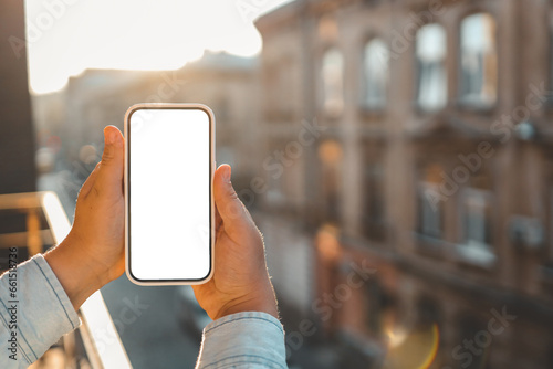 Phone in hands with isolated screen on the background of ancient buildings photo