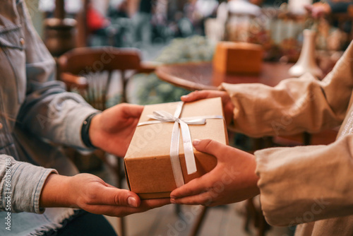 Gift box with bow in hands