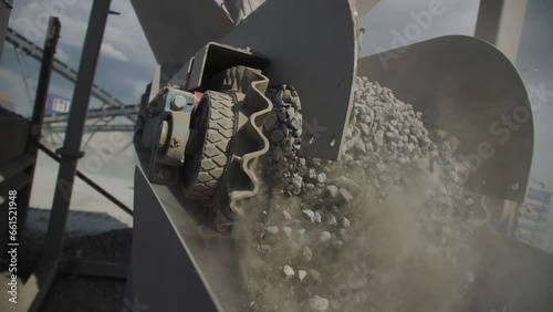 Conveyor belt moves transporting crushed granite in mining quarry closeup. Production line carries stone crumbles in rock digging pit