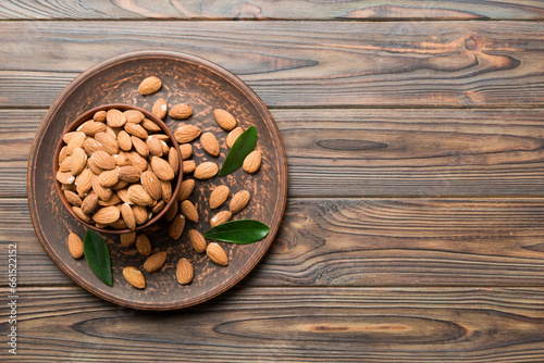Fresh healthy Almond in bowl on colored table background. Top view