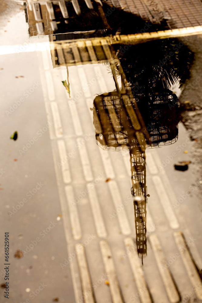 Reflexo em poça d`água na calçada da Avenida Paulista, cidade de São Paulo, Brasil. 