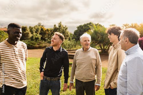 Happy multigenerational group of men with different ethnicities having fun in a public park - People diversity concept