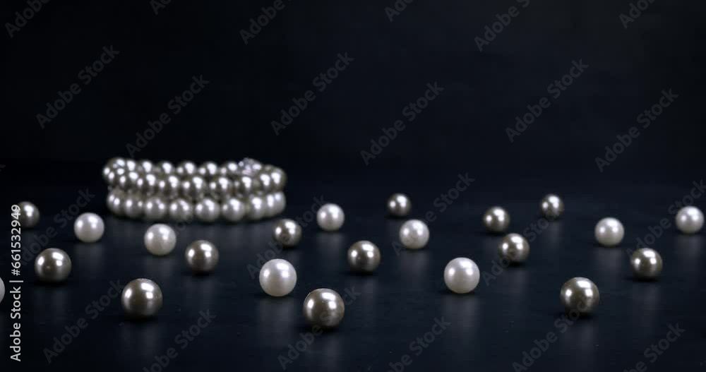 White and gray pearls and bracelets on black background. Fashion, accessories, jewelry, luxury, wealth concept. Dolly shot 4k White and gray pearls and bracelets on black background. Fashion, accessories, jewelry, luxury, wealth concept. Dolly shot 4k