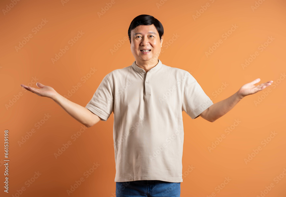 Portrait of middle-aged Asian man posing on brown background Portrait of middle-aged Asian man posing on brown background