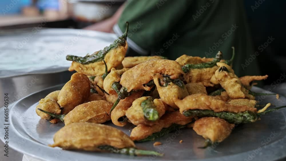 A closeup of fresh fried mirchi bajji or fried fritters on a plate at a hotel A closeup of fresh fried mirchi bajji or fried fritters on a plate at a hotel
