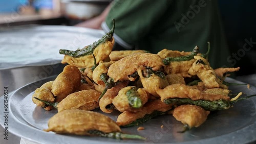 A closeup of fresh fried mirchi bajji or fried fritters on a plate at a hotel photo