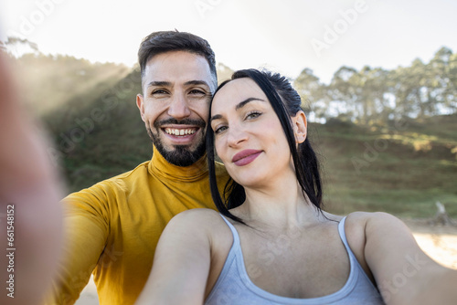 Happy couple taking selfie in front of paradise beach - Two tourists having fun on romantic summer vacation - Honeymoon - Vacation and travel lifestyle concept