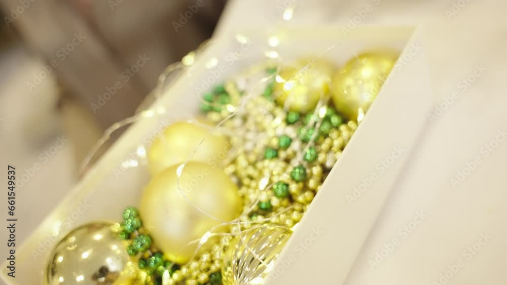 Close up, open box with Christmas decorations: golden balls, garlandes and Christmas lights on blurred background. Close up, open box with Christmas decorations: golden balls, garlandes and Christmas lights on blurred background.