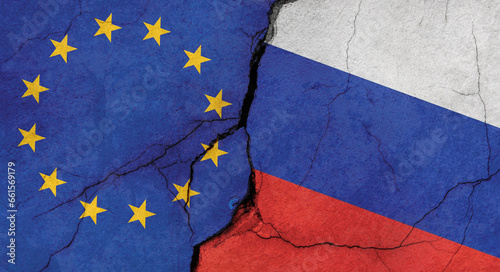 EU and Russian flags, concrete wall texture with cracks, grunge background, military conflict concept